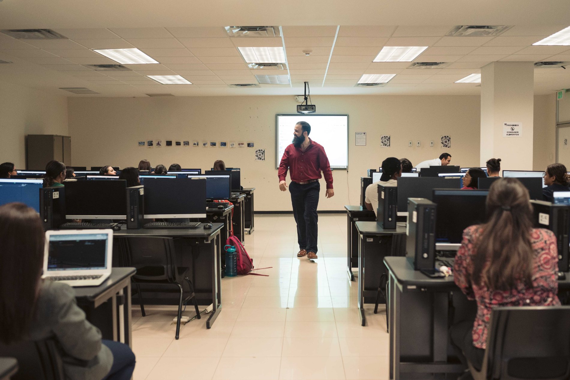 Carlos walking a computer lab during class
